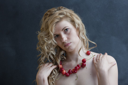 Young sexy blonde in the studio. (Beads from a sweet cherry).