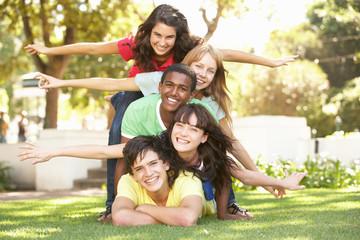 Fototapeta premium Group Of Teenagers Piled Up In Park