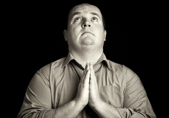 Fototapeta premium dark black and white overweight male praying