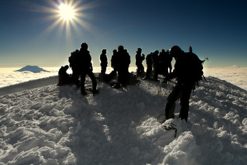 group of people on the summit of a high mountain