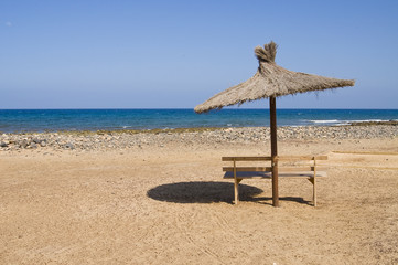 Bench and umbrella on a beach