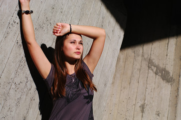 Fashion model by the concrete wall