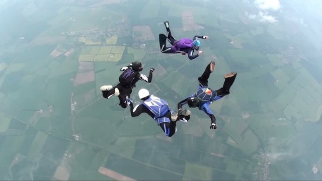 Four skydivers in freefall doing formations