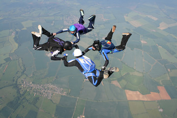 Four skydivers doing formations