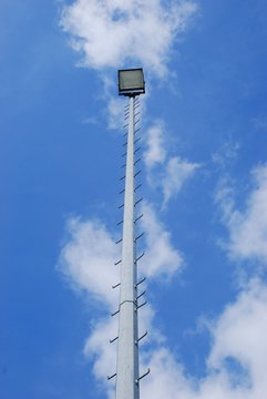 Kleiner Flutlichtmast vor blauem Himmel