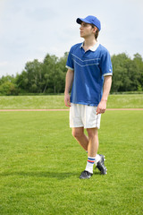 Junger Fußballspieler steht auf dem Rasen