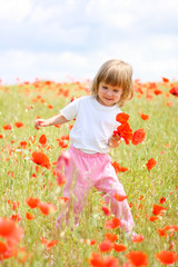Girl on meadow with a red poppies