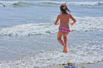 Enfant sautant par dessus les vagues