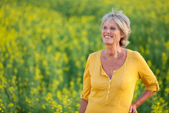 portrait einer seniorin im rapsfeld