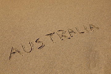 Australia drawn in the sand at the beach on an angle.