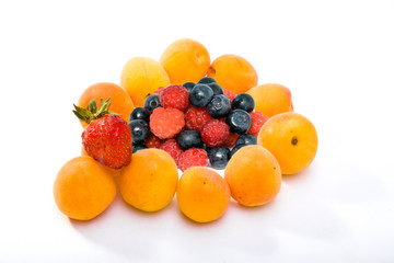 Ripe apricots and berries of strawberry, raspberry and bilberry