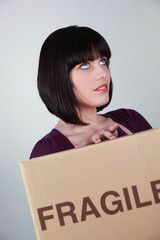 Jeune femme avec carton de déménagement