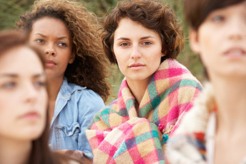 Fototapeta premium Close Up Of Group Of Girls Sitting On Beach Together