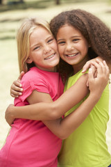 Two Girls In Park Giving Each Other Hug