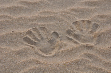 empreintes de main dans le sable