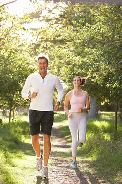 Middle Aged Couple Jogging In Park