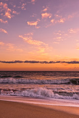 Fototapeta na wymiar Ocean surf under golden sunset clouds