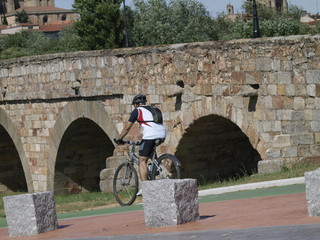 Puente de piedra medieval y ciclista en Salamanca