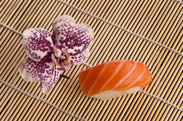 Sushi et orchidée sur un tapis de bambou