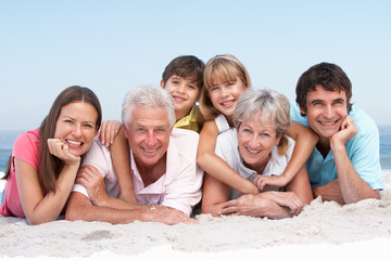 Three Generation Family Relaxing On Beach Holiday