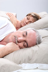 Obraz na płótnie Canvas Couple de seniors allongés dans un lit