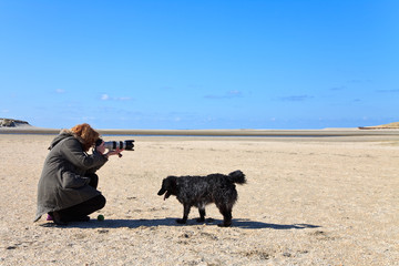 Woman photographer in the sand dunes on the beach