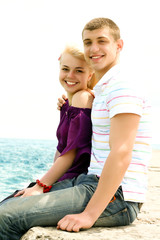 Fototapeta na wymiar Portrait of caucasian teen couple embracing on the beach