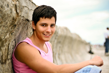 Fototapeta na wymiar Glamour handsome teenager in pink t-shirt outdoors