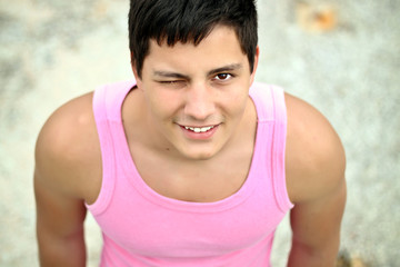 Fototapeta na wymiar Handsome man in pink t-shirt winking outdoors
