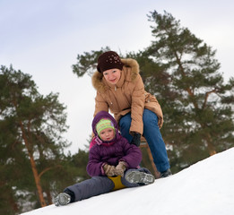 Fototapeta na wymiar mother with child sliding in the snow