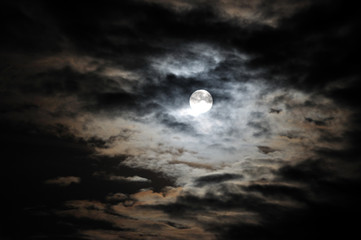 Full moon and white clouds on black night sky