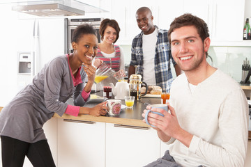 Fototapeta na wymiar Group Of Young Friends Preparing Breakfast In Modern Kitchen