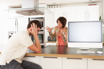 Young Couple Discussing Personal Finances In Modern Kitchen