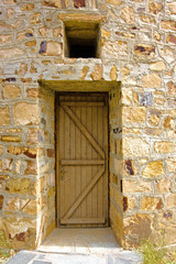 Front door of traditional  built with stones windmill in Greece
