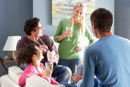 Group Of  Friends Enjoying Chinese Takeaway Meal At Home