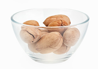 Pecan nuts in a glass bowl isolated on white