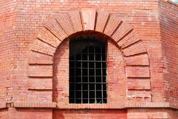 Window with a lattice in an old brick wall