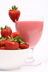 Strawberries in a bowl and a strawberry shake in a glass