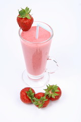 Strawberry shake in a glass with a straw with a strawberries