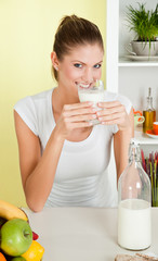 Young beauty woman drinking a glass of milk