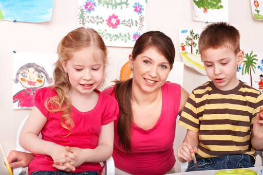 Children with teacher in play room.