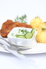 Pork chop,mashed potatoes and cucumber salad in a bowl