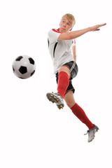 Fototapeta na wymiar Soccer player kicking the ball isolated on white