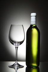 Bottle of white wine and empty wine glass