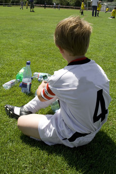 Exausted Boy Takes A Rest In The Halftime Of A Football Match