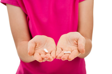 Girl holding pills isolated on white background