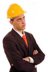 Pensive young engineer with a yellow helmet on white background