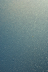 Dew drops on blue metallic surface