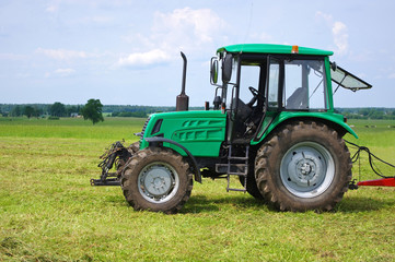 Green tractor in green field