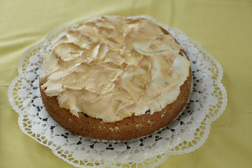 Fruit cake with meringue topping on a yellow table cloth